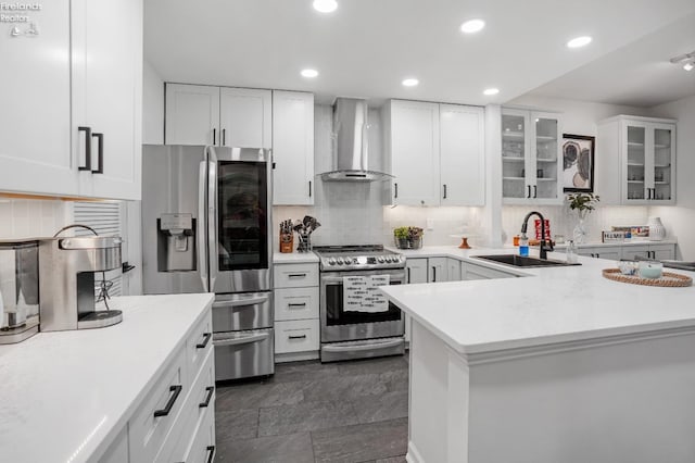 kitchen with wall chimney exhaust hood, stainless steel appliances, sink, and white cabinets