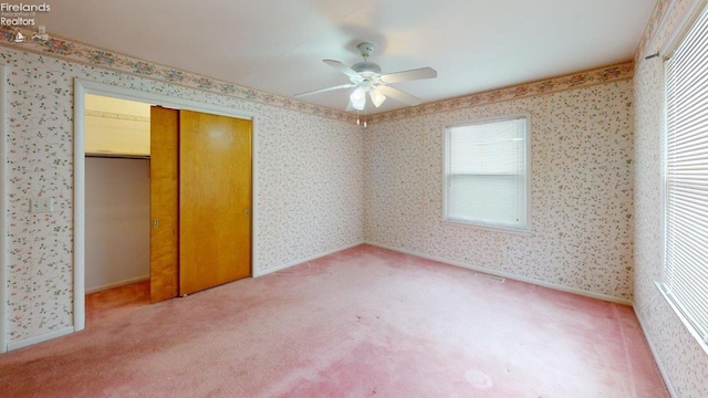 unfurnished bedroom with ceiling fan, carpet, and a closet