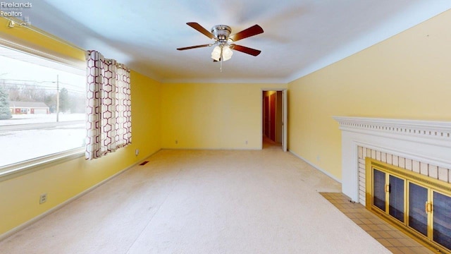 unfurnished living room with ceiling fan and a fireplace