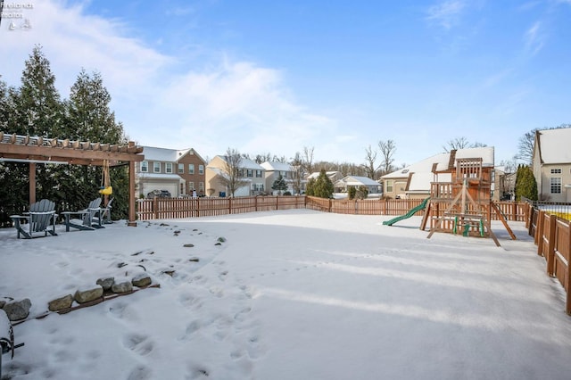 snowy yard featuring a pergola and a playground