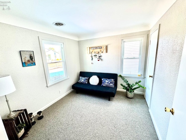 living area with a healthy amount of sunlight and carpet