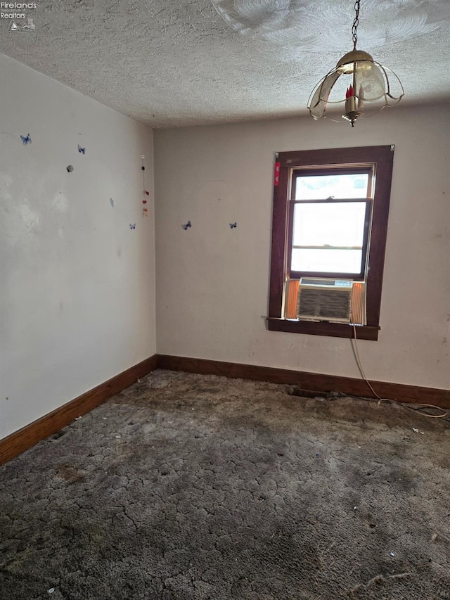 carpeted spare room featuring cooling unit and a textured ceiling