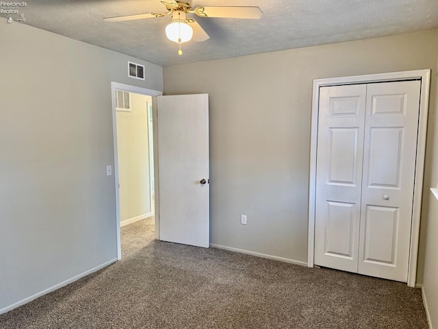 unfurnished bedroom featuring ceiling fan, carpet, a textured ceiling, and a closet