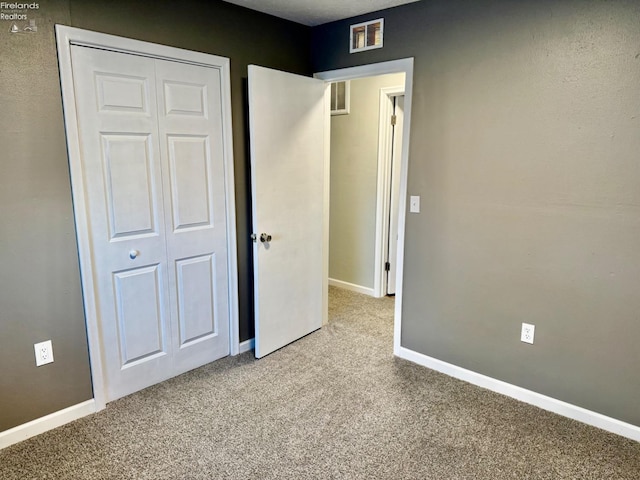 unfurnished bedroom featuring carpet floors and a closet