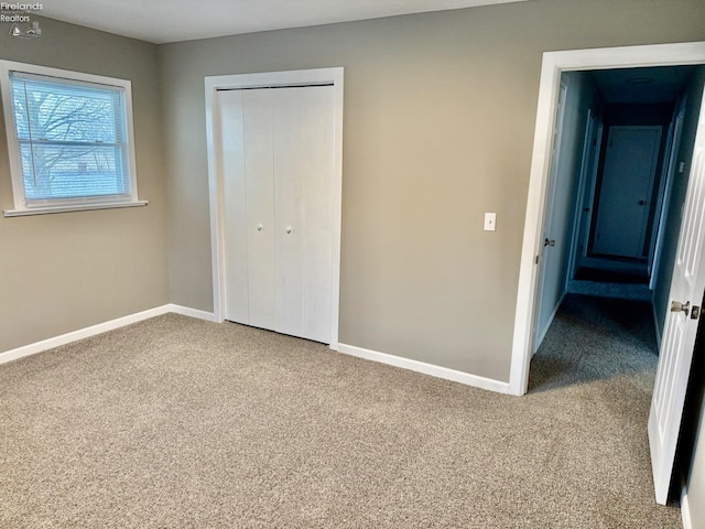 unfurnished bedroom with carpet floors and a closet