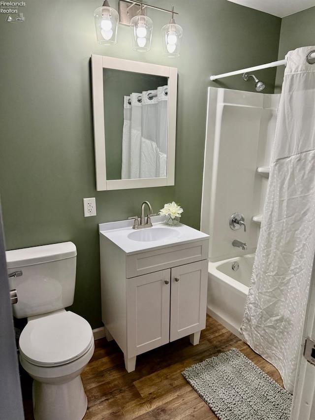 full bathroom with hardwood / wood-style flooring, vanity, toilet, and shower / tub combo