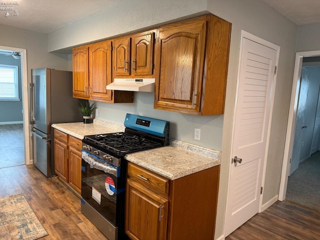 kitchen with a textured ceiling, dark hardwood / wood-style floors, ceiling fan, and appliances with stainless steel finishes