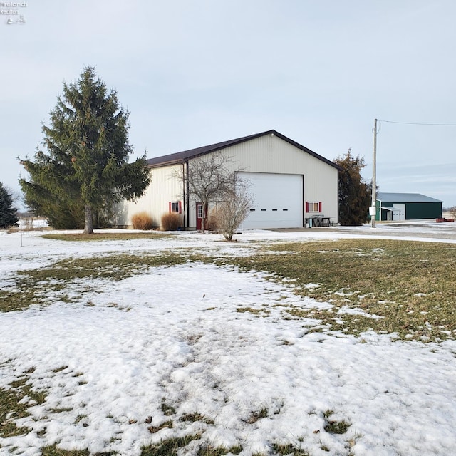 snow covered property with a garage