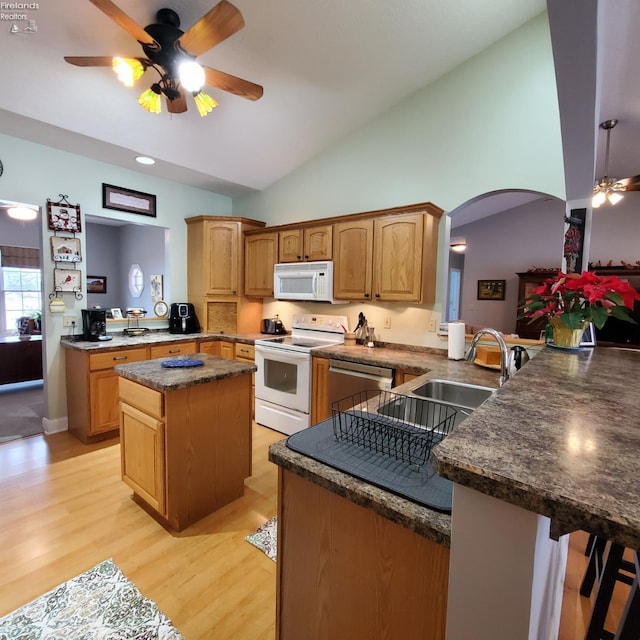 kitchen with a kitchen bar, white appliances, light hardwood / wood-style flooring, kitchen peninsula, and ceiling fan