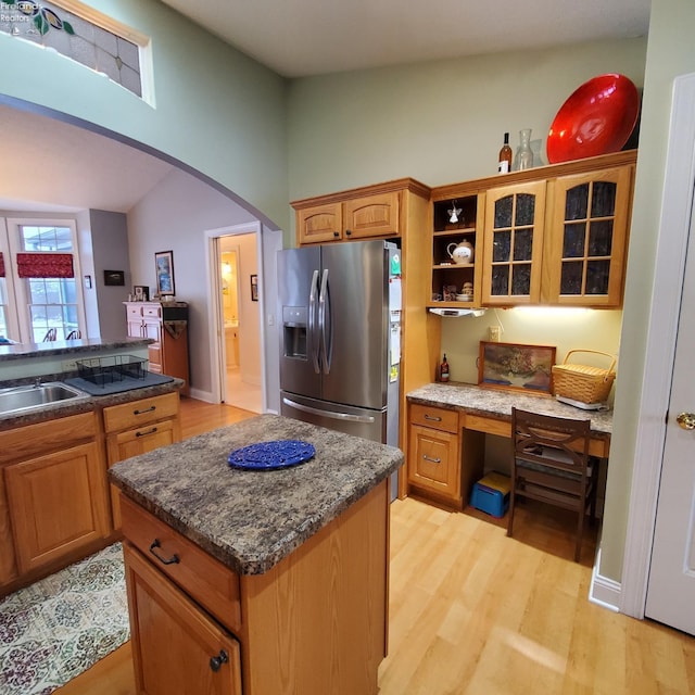 kitchen featuring built in desk, sink, a center island, light hardwood / wood-style floors, and stainless steel fridge with ice dispenser