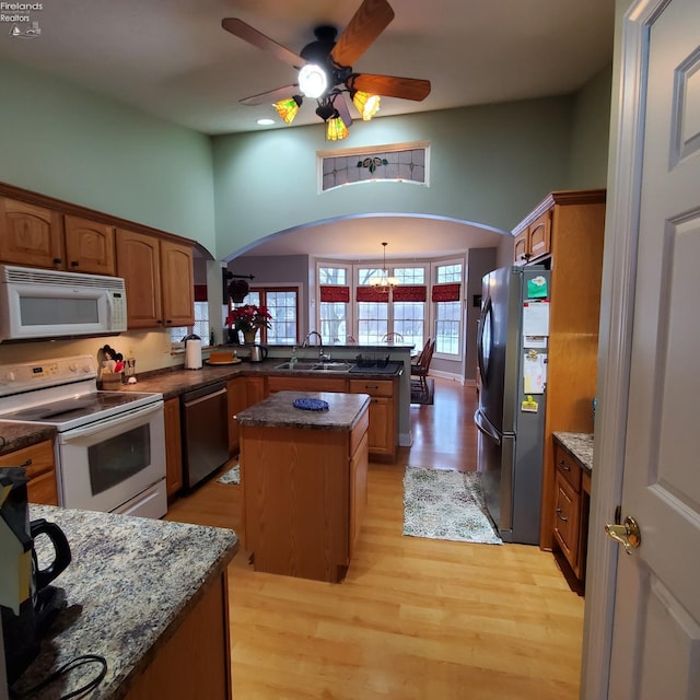 kitchen featuring sink, a center island, light hardwood / wood-style flooring, appliances with stainless steel finishes, and kitchen peninsula