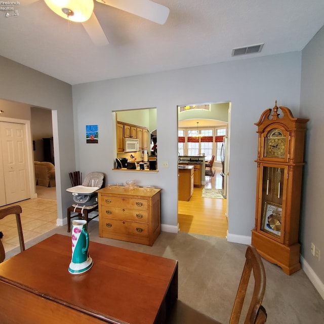 dining space with light colored carpet and ceiling fan