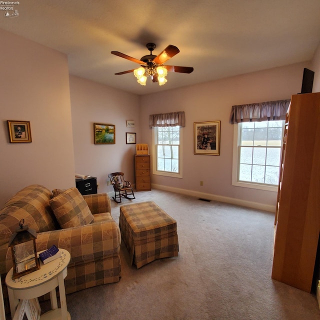 carpeted living room with ceiling fan