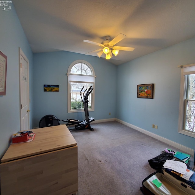 carpeted home office featuring lofted ceiling and ceiling fan