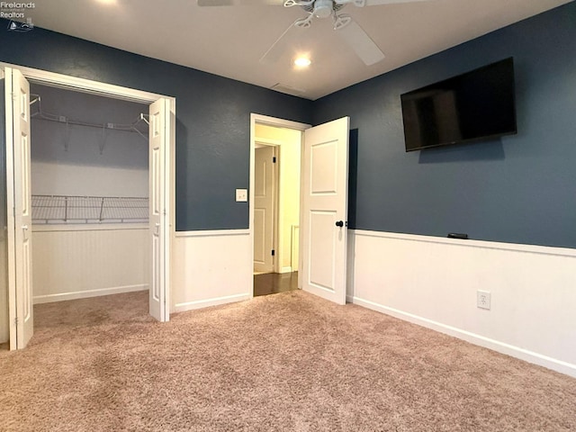 unfurnished bedroom with carpet floors, ceiling fan, and a closet