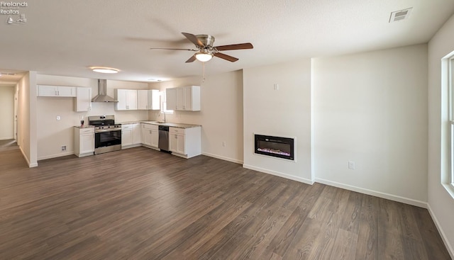 kitchen with white cabinetry, wall chimney range hood, dark wood-type flooring, and stainless steel appliances