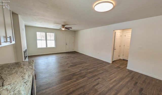 empty room featuring dark wood-type flooring and ceiling fan