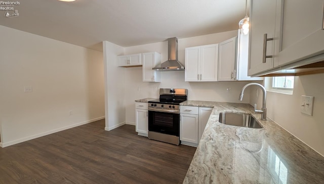 kitchen featuring wall chimney exhaust hood, sink, pendant lighting, stainless steel electric stove, and white cabinets