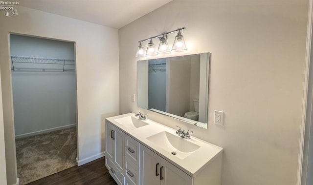 bathroom with vanity, toilet, and wood-type flooring