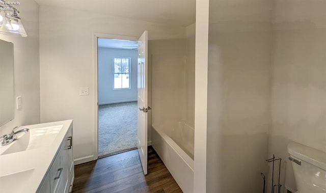 bathroom featuring vanity, wood-type flooring, and toilet