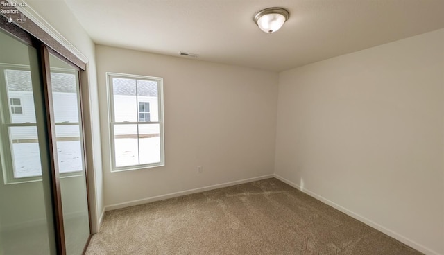 spare room featuring light colored carpet