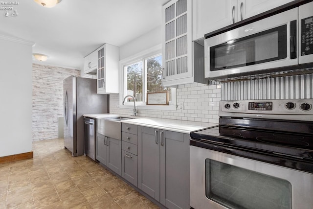 kitchen with sink, white cabinetry, tasteful backsplash, appliances with stainless steel finishes, and gray cabinets