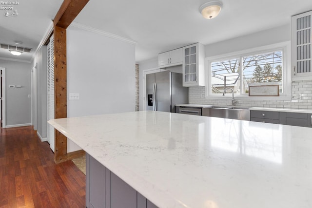 kitchen with white cabinetry, sink, gray cabinetry, stainless steel fridge, and light stone countertops