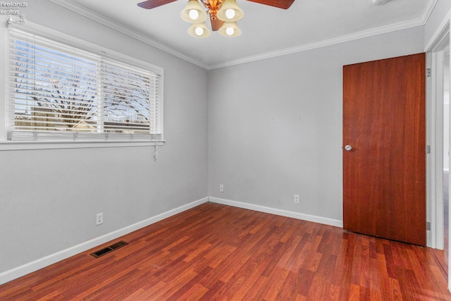 empty room with ornamental molding, dark hardwood / wood-style floors, and ceiling fan