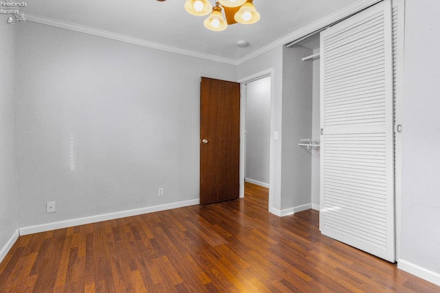 unfurnished bedroom with ornamental molding, dark hardwood / wood-style flooring, and a closet