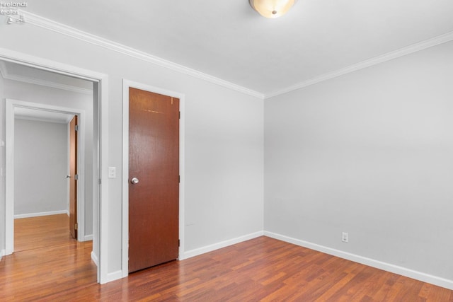 unfurnished room featuring hardwood / wood-style floors and ornamental molding