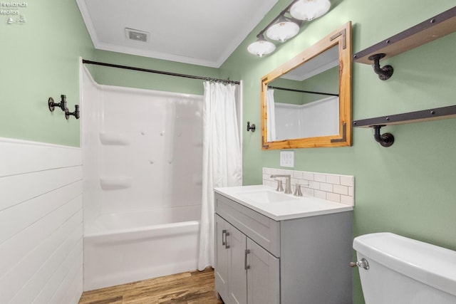 full bathroom featuring shower / tub combo with curtain, wood-type flooring, ornamental molding, vanity, and toilet