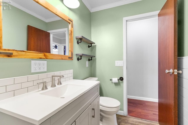 bathroom with crown molding, vanity, wood-type flooring, decorative backsplash, and toilet