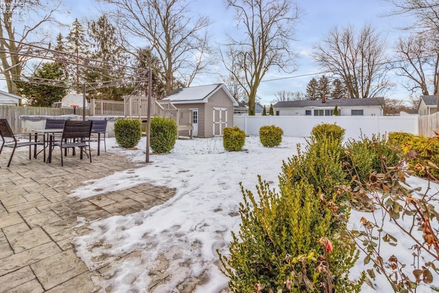 snowy yard with an outbuilding and a patio