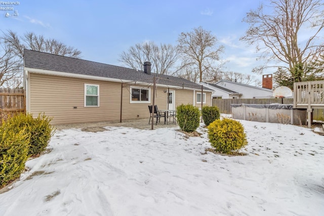 view of snow covered rear of property