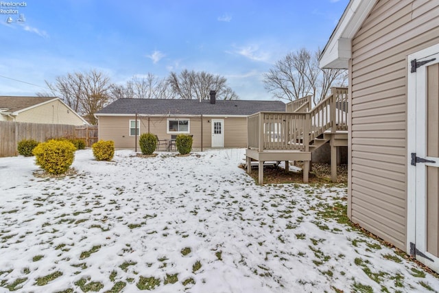 snow covered property with a deck