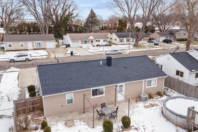 snow covered house featuring central AC unit