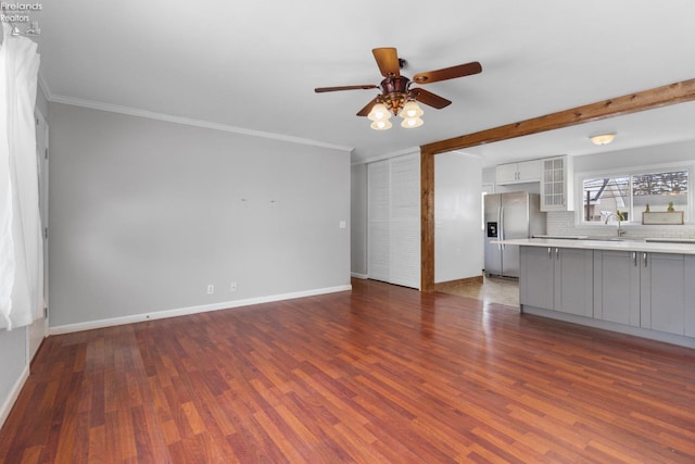 unfurnished living room featuring crown molding, ceiling fan, dark hardwood / wood-style floors, and sink