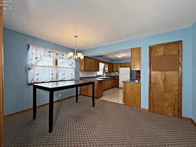 kitchen with sink, light carpet, decorative light fixtures, a chandelier, and white fridge