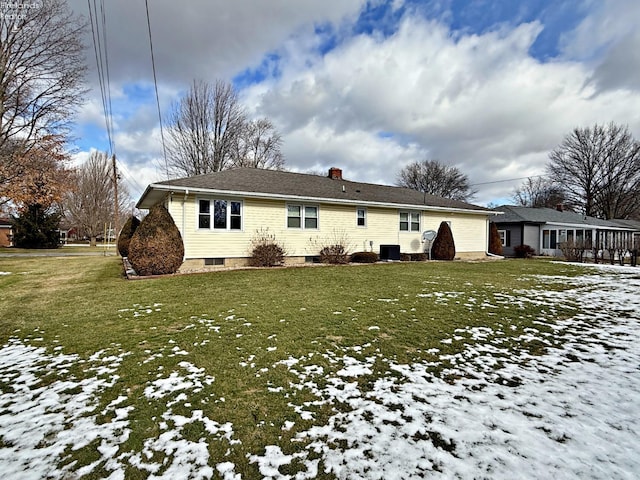 snow covered property featuring a yard and central air condition unit