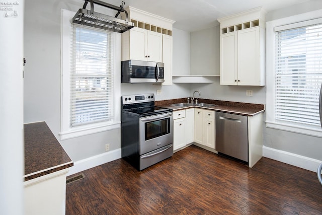 kitchen featuring white cabinetry, appliances with stainless steel finishes, dark wood-type flooring, and sink