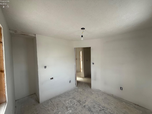 unfurnished room with a textured ceiling