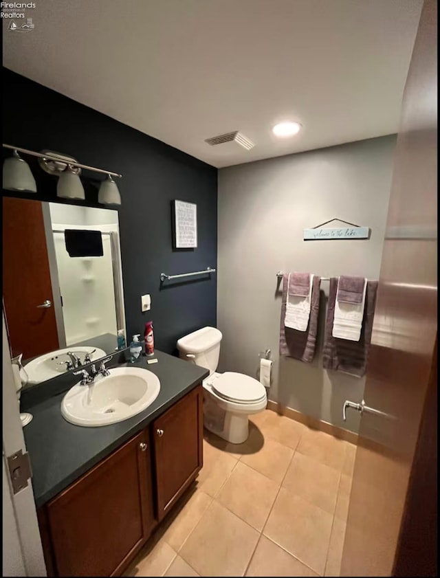 bathroom featuring vanity, toilet, and tile patterned flooring