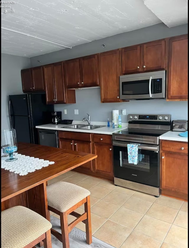 kitchen featuring sink, light tile patterned floors, and appliances with stainless steel finishes