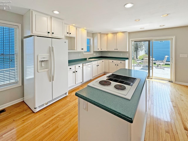 kitchen with sink, white appliances, light hardwood / wood-style flooring, and white cabinets