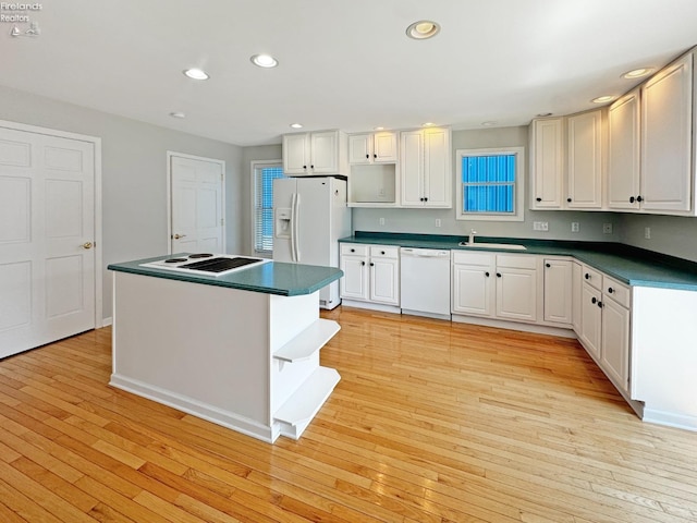 kitchen with sink, white cabinets, white appliances, and light hardwood / wood-style flooring