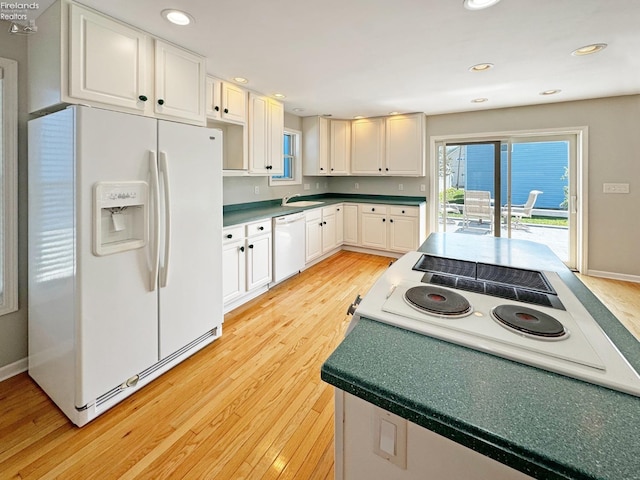 kitchen with white cabinetry, sink, white appliances, and light hardwood / wood-style floors