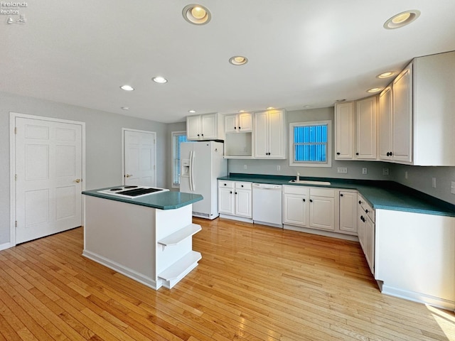 kitchen featuring sink, white cabinets, a center island, white appliances, and light hardwood / wood-style flooring