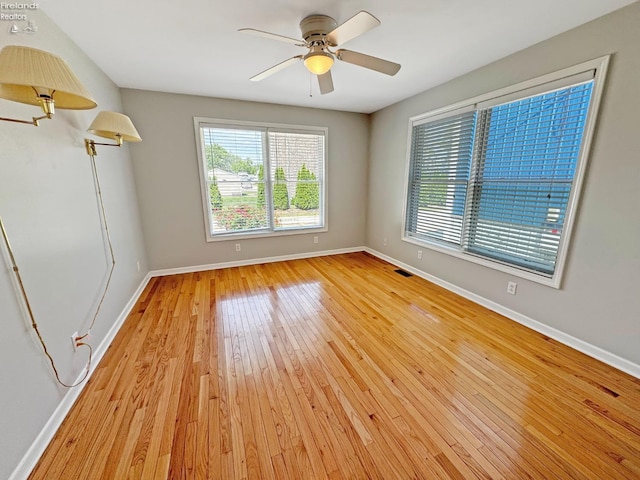 empty room with ceiling fan and light wood-type flooring