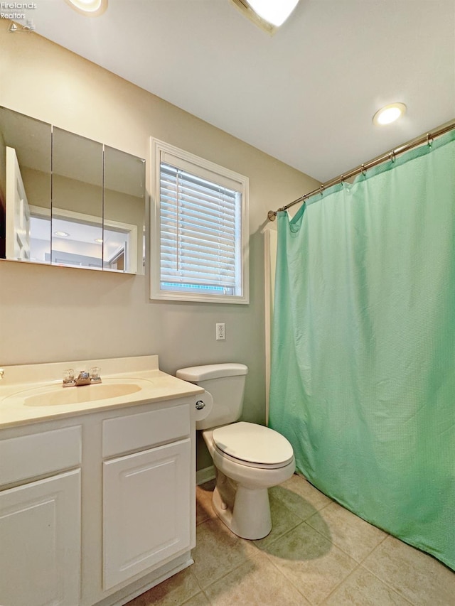 bathroom featuring vanity, a shower with shower curtain, tile patterned floors, and toilet