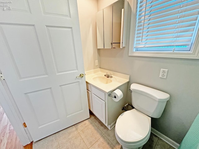 bathroom with tile patterned flooring, vanity, and toilet